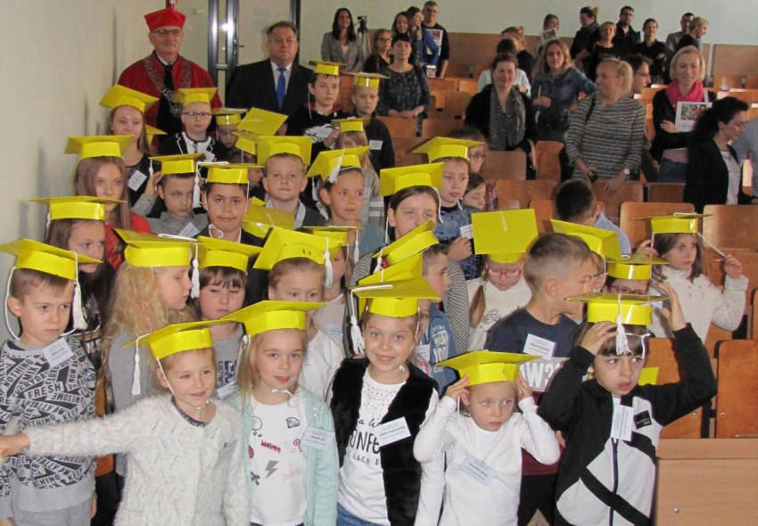 zdjęcie przedstawia dzieci, władze uczelni, rodziców podczas uroczystej inauguracji roku akademickiego